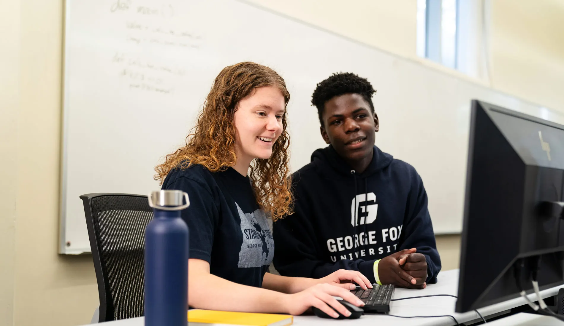 Students work together at a computer